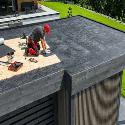 Worker installing EPDM on a residential flat roof in Toronto &mdash; flat roof repair by Right Choice Roofing and Repair.