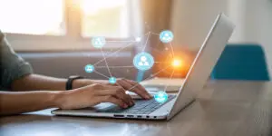 Hands typing on a laptop with digital network icons, symbolizing contacting Toronto slate roofing experts at Right Choice Roofing and Repair.