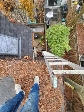 Clogged gutters filled with leaves on a Toronto home, increasing the risk of winter roof leaks.