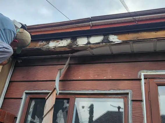 Exterior roof damage on a Toronto home showing rotted fascia and failing eavestroughs, common exterior signs of roof leaks that may require roof repair, roof replacement, or slate roofing repairs.