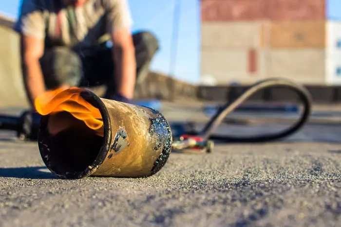 Torch-applied flat roof repair on a Toronto building, showing professional roof repair work to seal membranes and prevent winter roof leaks.