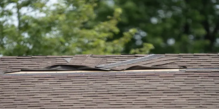 Lifted asphalt shingles on a Toronto roof after storm damage, showing hidden roof issues that can lead to leaks and require professional roof repair.
