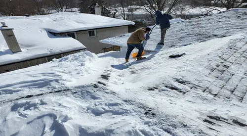 Professional snow removal service clearing heavy snow from Toronto residential roof safely