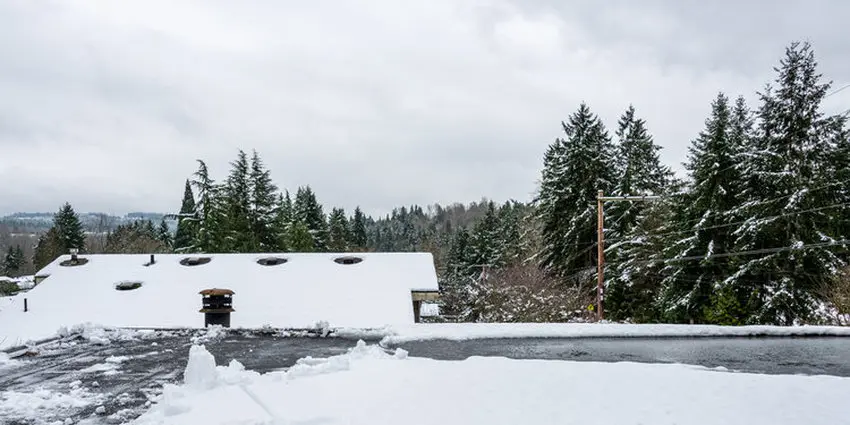Snow and ice buildup on a flat roof requiring winter removal in Toronto