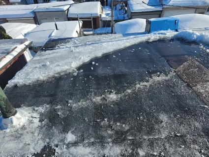 Ponding water and ice on flat roof in Toronto showing serious drainage problems requiring emergency flat roof repair