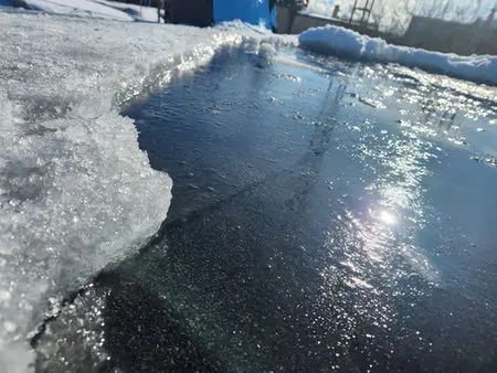 Standing water and ice on flat roof in Junction Toronto showing drainage problems requiring flat roof repair