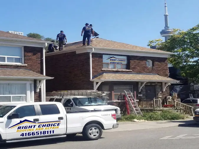 Right Choice Roofing and Repair crew working on residential roof replacement on a Toronto brick home with the Right Choice Roofing and Repair branded truck and company sign visible and CN Tower in the background