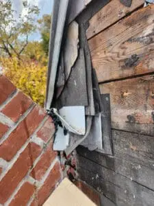 Decades of patchwork Flashing layers built up above a brick Chimney on a Rosedale Toronto heritage Slate Roof exposed during full replacement by Right Choice Roofing and Repair