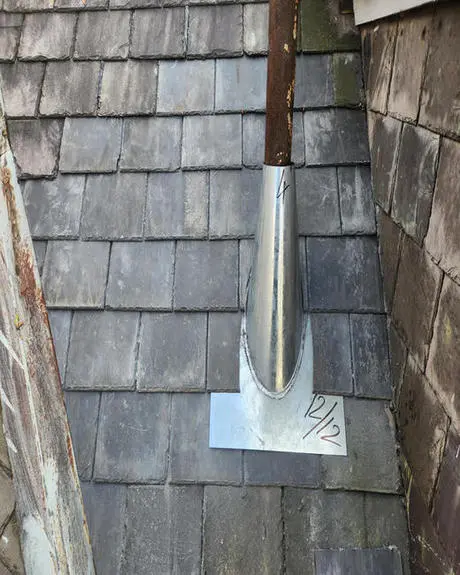 Completed slate roof repair with new plumbing exhaust flange and precision-fitted natural slate tiles on a Toronto heritage home