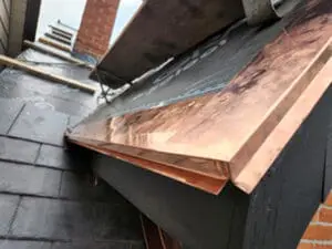 Progress photo showing custom fabricated copper drip edge installed along fascia and gable to reinforce edge and prevent wildlife infestation during slate roof replacement in Harbord Village Toronto by Right Choice Roofing and Repair