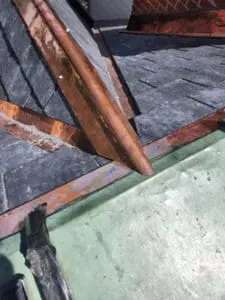 Final detail photo showing completed copper dormer ridge cap copper valley copper drip edge and copper flat roof all tied together at dormer base during complete slate roof replacement in Harbord Village Toronto by Right Choice Roofing and Repair