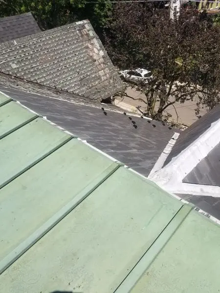 Before photo showing deteriorated slate roof tiles adjacent to copper flat roof section in Harbord Village Toronto prior to replacement by Right Choice Roofing and Repair