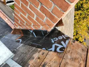 Skilled Grace Ice and Water Shield underlayment Flashing installation turned up the brick Chimney wall on a Rosedale Toronto heritage Slate Roof by Right Choice Roofing and Repair