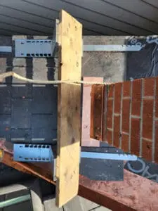 Progress photo showing work platform set up around brick chimney to provide safe access for expert copper chimney flashing installation during slate roof replacement in Harbord Village Toronto by Right Choice Roofing and Repair