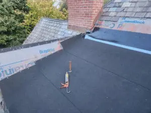 Modified bitumen base sheet fully installed on a Rosedale Toronto flat Roof with GAF DiamondDeck and StormGuard underlayment running up the adjoining Dormer sloped Roofs