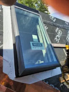 Progress photo close-up of new Velux deck mount skylight installed in Grace Select underlayment on slate roof with brick chimney visible in Harbord Village Toronto by Right Choice Roofing and Repair