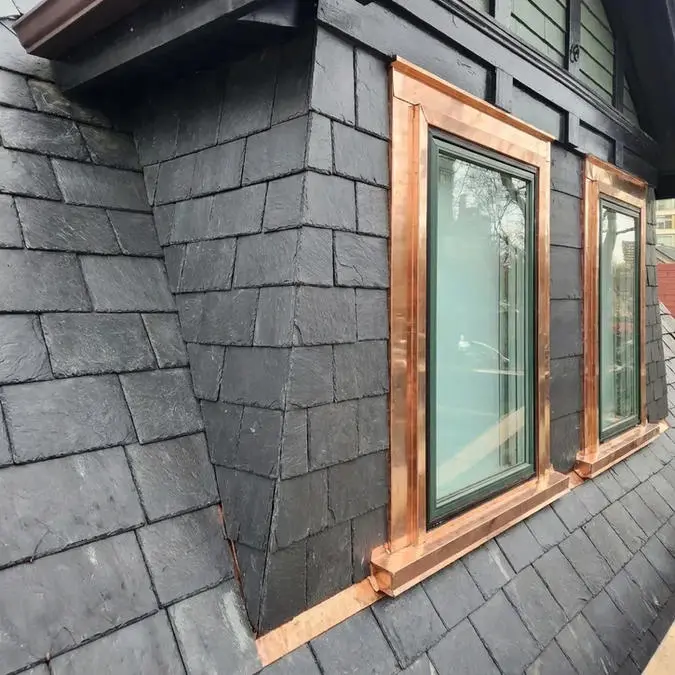 Completed slate roof installation in Toronto showing natural slate tiles and custom fabricated copper window frame, sill and lintel coverings by Right Choice Roofing and Repair.
