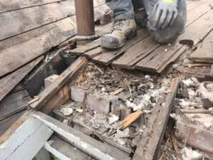 Extensive Roof structure rot exposed after flat Roof tear-off in Rosedale Toronto showing damaged framing, old brick, and debris below the Sheathing