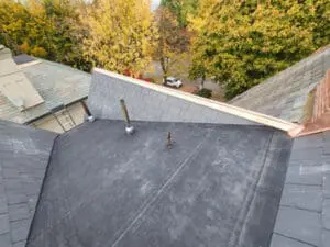 Final completed new modified bitumen flat Roof with aluminum high dome plumbing exhaust flanges, new natural Slate Roof on the Dormer, and copper Ridge Cap on a Rosedale Toronto heritage home by Right Choice Roofing and Repair
