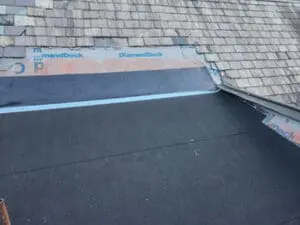 Progress photo of a natural Slate Roof and flat Roof replacement on a heritage home in Rosedale Toronto, showing modified bitumen base sheet on the flat section and GAF DiamondDeck synthetic underlayment on the lower Slate slope, with original Slate tiles still in place above &mdash; work by Right Choice Roofing and Repair
