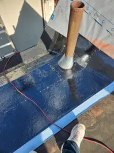 New aluminum high dome plumbing exhaust flange installed around the old cast-iron pipe on a Rosedale Toronto flat Roof with blue ice and water shield membrane in place