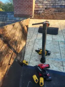 New OSB plywood fully installed on the flat Roof section of a Rosedale Toronto heritage home with old cast-iron vent pipe, Milwaukee and DeWalt tools on the new deck