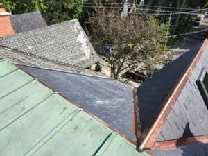 Final photo showing completed slate roof replacement with new natural slate tiles copper ridge cap copper valley and copper drip edge on heritage home in Harbord Village Toronto by Right Choice Roofing and Repair