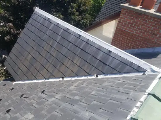 Before photo showing original lead valley flashing between slate roof and brick chimney in Harbord Village Toronto prior to copper conversion by Right Choice Roofing and Repair