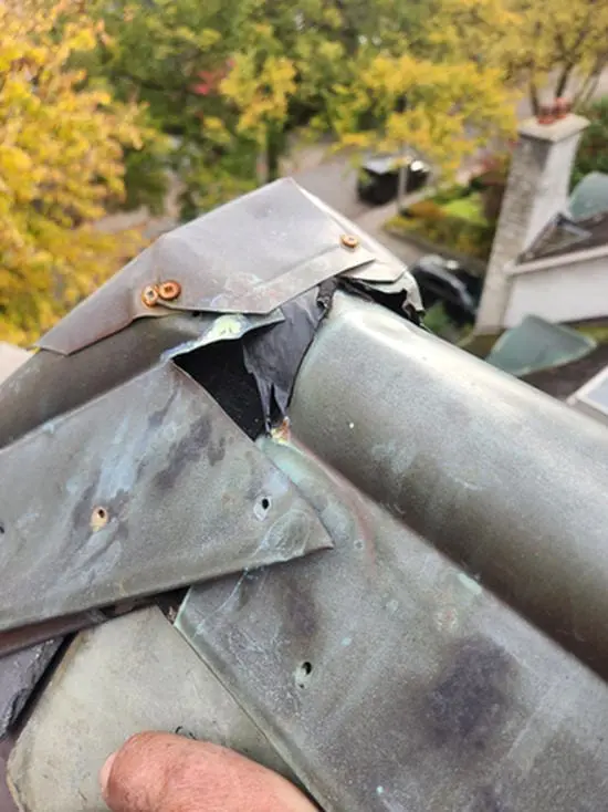 Leaking copper Ridge Cap on a Rosedale Toronto heritage Slate Roof showing torn seam, poor overlap, wrong fasteners, and galvanic corrosion before replacement by Right Choice Roofing and Repair