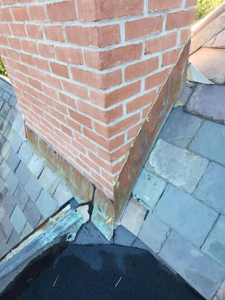 Before photo of a leaking brick Chimney with damaged copper Flashing, failed Counter Flashing, and open gap at the Slate Roof in Rosedale Toronto