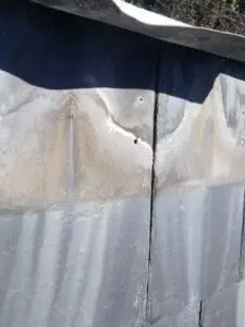 Progress photo showing cracked and split slate tile with water staining tracking down through crack to fastening points on Harbord Village Toronto roof by Right Choice Roofing and Repair