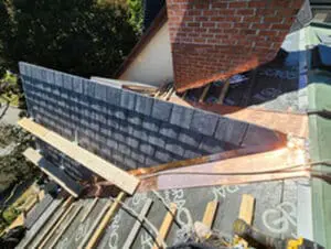 Progress photo from flat roof showing full dormer with new slate tiles installed on left face copper valley flashing at junction and Grace Select on right face awaiting slate during lifetime warranty slate roofing system installation in Harbord Village Toronto by Right Choice Roofing and Repair