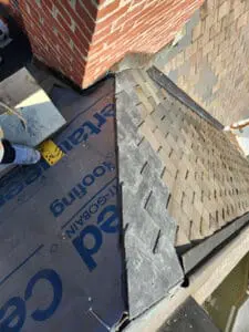 Local Slate Roofer tying in natural Slate tiles with precision cuts at a Valley junction between two Dormer sloped Roofs near a brick Chimney on a Rosedale Toronto heritage home by Right Choice Roofing and Repair