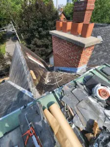 Progress photo showing full scope of slate roof replacement project mid-job with old slate tiles, new underlayment, staged copper stock and tools visible in Harbord Village Toronto by Right Choice Roofing and Repair