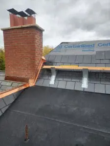 Completed copper Counter Flashing and Ridge Cap at a brick Chimney with new natural Slate Roof on the right, CertainTeed DiamondDeck underlayment on the upper slope, and new modified bitumen flat Roof on a Rosedale Toronto heritage home by Right Choice Roofing and Repair
