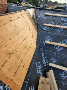 Progress photo showing transition between new plywood sheathing and Grace Select underlayment on main slope with 2x4 step ups and copper roll staged during slate roof replacement in Harbord Village Toronto by Right Choice Roofing and Repair