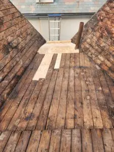 Roof water damage repair completed on a Rosedale Toronto heritage home with patched board Sheathing on both Slate slopes and flat section, ready for new plywood installation