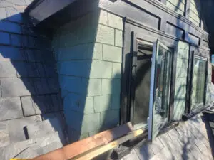 Before photo of a slate dormer showing specialized work platform setup for a roofing repair project in Toronto.