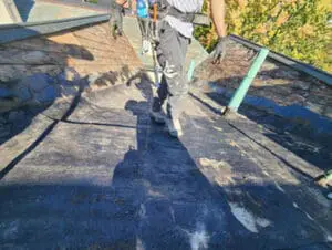 Tear-off in progress on a Rosedale Toronto Slate Roof and flat Roof replacement showing exposed old underlayment and hand removal of original materials