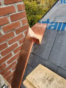 Custom hand-fabricated copper Back Pan Chimney Flashing with peaked spine installed at a brick Chimney on a Rosedale Toronto heritage Slate Roof to split and divert water flow by Right Choice Roofing and Repair