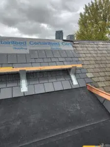 One side of a Ridge completed with natural Slate Roof and new copper Ridge Cap, with CertainTeed DiamondDeck underlayment and work platform on the opposite side ready for new Slate on a Rosedale Toronto heritage home by Right Choice Roofing and Repair