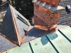 Final photo showing completed slate roof replacement with new slate tiles copper valley copper ridge cap complete copper chimney flashing kit and Velux skylight on heritage home in Harbord Village Toronto by Right Choice Roofing and Repair