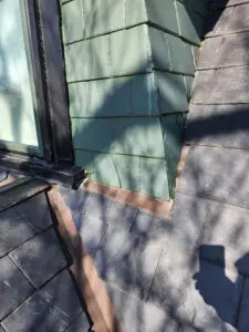 Deteriorating slate roof in Toronto showing wildlife damaged slate tiles, failing dormer flashing, and worn valley before replacement by Right Choice Roofing and Repair.