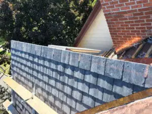 Progress photo looking along ridge showing new slate tiles fully installed across main slope with copper drip edge along bottom and ridge awaiting closure caps during slate roof replacement in Harbord Village Toronto by Right Choice Roofing and Repair
