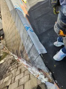 Precise tile installation of the final courses of natural Slate closing off the top of a Valley junction on a Rosedale Toronto heritage Roof with ice and water shield in place, ready for copper Valley and Ridge Cap