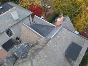 Wide aerial view of a completed natural Slate Roofing and flat Roof replacement on a Rosedale Toronto heritage home with multiple Dormers and copper Flashing