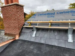 New copper Step Flashing installed up a brick Chimney with CertainTeed DiamondDeck underlayment on the Dormer sloped Roof and completed natural Slate courses below on a Rosedale Toronto heritage home by Right Choice Roofing and Repair
