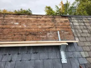 Last of the old Slate tiles and copper Ridge Cap removed along the Ridge line of a Rosedale Toronto heritage Roof exposing the original board Sheathing with a work platform set up by Right Choice Roofing and Repair