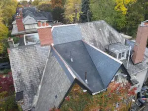Overhead aerial view of a completed natural Slate Roof and flat Roof replacement on a Rosedale Toronto heritage home with multiple Chimneys and copper Flashing