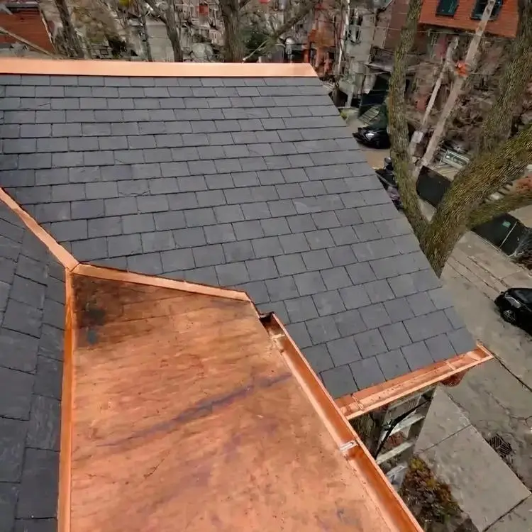 Completed slate roof replacement in Toronto showing new natural slate tiles, custom copper valley, copper flat roof and eavestrough installation by Right Choice Roofing and Repair.
